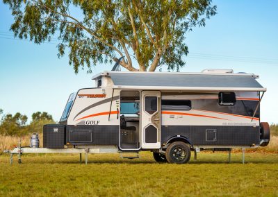 Stylish caravan parked under a tree.